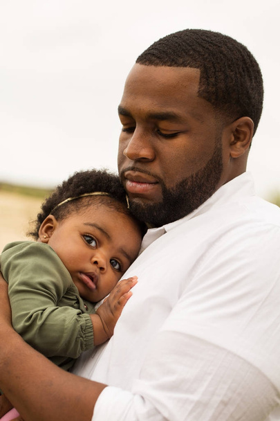 African American father holding his daughter. - 写真・画像