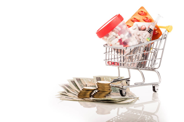 medicines in basket running into dollars isolated on white background - Φωτογραφία, εικόνα