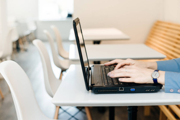 girl freelancer in blue shirt working on laptop - Фото, зображення