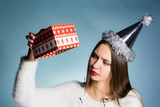 dissatisfied young girl with a cap on her head received an empty box without a gift for the new year - Foto, Imagem