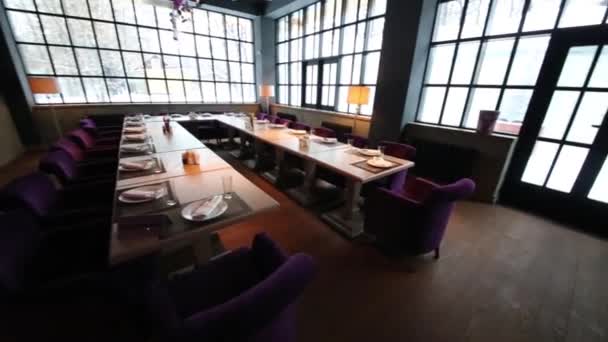 Tables and purple armchairs in restaurant with large windows - Footage, Video