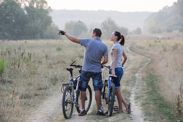 田舎で自転車で幸せな若いカップル - 写真・画像