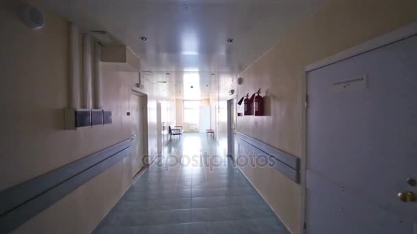 Movimiento en pasillo con puertas en hospital. Texto en la puerta, pared: salida, cirugía
 - Metraje, vídeo