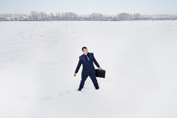Yang liikemies pukeutunut puku näyttää eksyksissä lunta autiomaassa
 - Valokuva, kuva