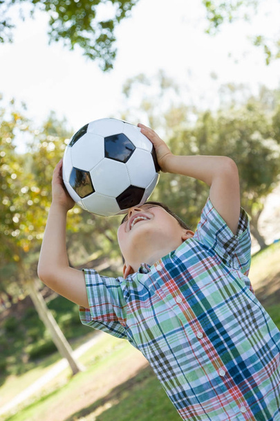 Lindo joven jugando con pelota de fútbol al aire libre en el parque
. - Foto, Imagen