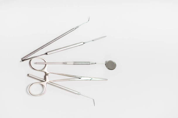 on a white background dental tools lie - Foto, afbeelding