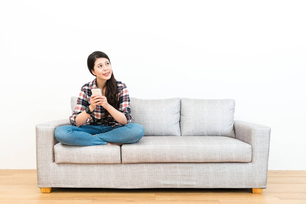 happy beautiful girl sitting on wooden floor sofa - Foto, afbeelding