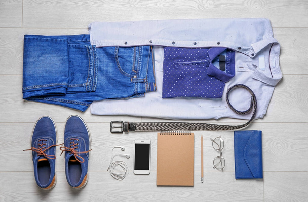 Set of hipster clothes on wooden floor, flat lay - Фото, изображение
