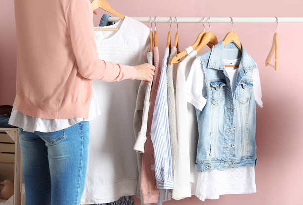Woman choosing clothes on rack in dressing room - Fotografie, Obrázek
