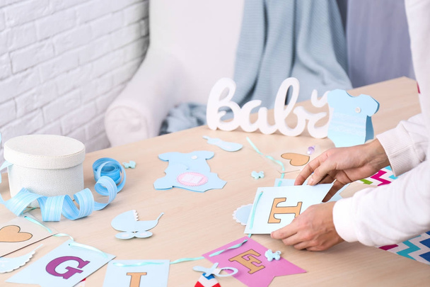 Woman preparing decorations for baby shower party on table - Foto, Imagem