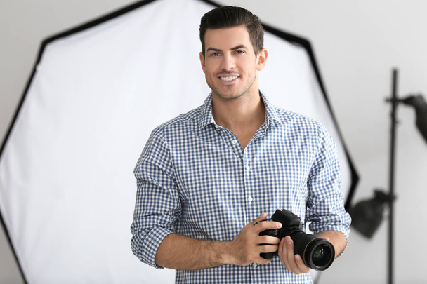 Young photographer with camera in professional studio - Φωτογραφία, εικόνα