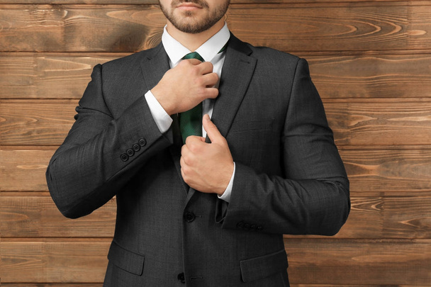 Handsome man in formal suit on wooden background, closeup - Photo, Image