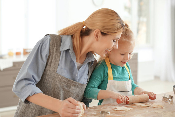 Mother and daughter with dough at table indoors - Fotoğraf, Görsel