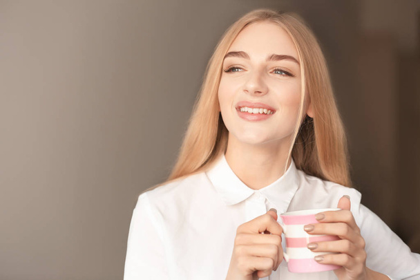 Smiling woman with cup of coffee indoors - Φωτογραφία, εικόνα