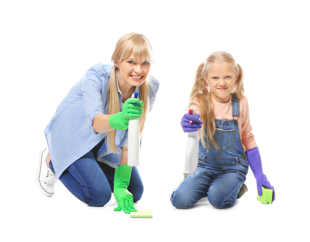 Pieni tyttö ja hänen äitinsä siivoustarvikkeet valkoisella taustalla
 - Valokuva, kuva