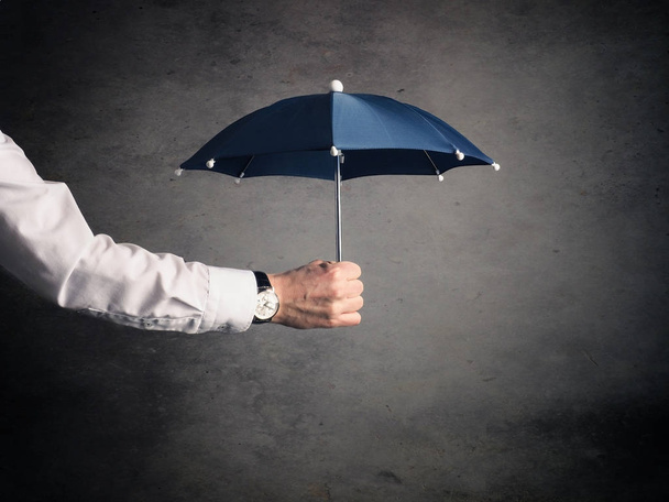Businessman with an umbrella - Фото, зображення