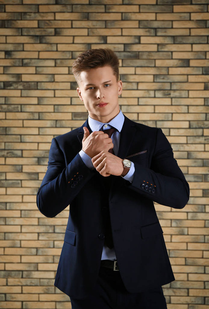 Handsome man in formal suit against brick wall - Фото, зображення