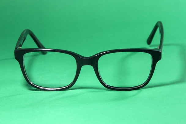 Black eyeglasses On a green background - Photo, Image