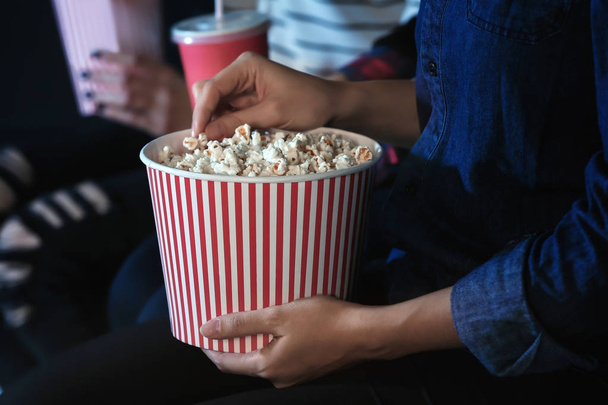 Woman eating popcorn in cinema, closeup - Foto, imagen