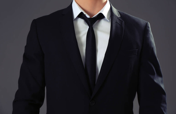 Knappe man in formele pak op grijze achtergrond, close-up - Foto, afbeelding