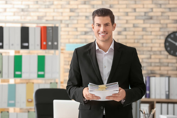 Young man with documents in office - Foto, immagini