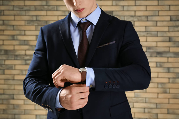 Handsome man in formal suit against brick wall, closeup - Foto, Bild