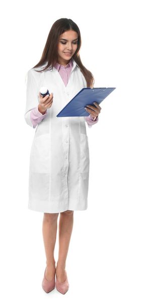 Young female pharmacist with medicament and clipboard on white background - Valokuva, kuva