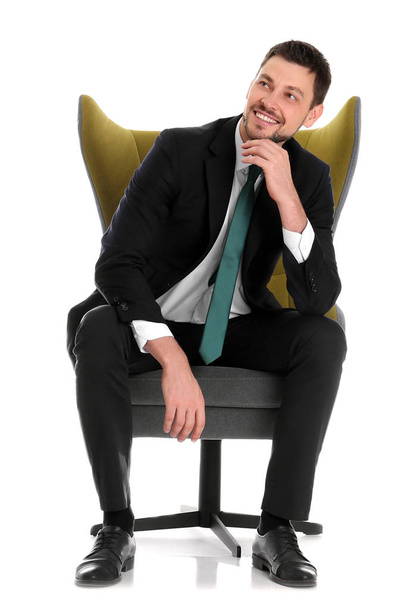 Handsome businessman sitting in comfortable armchair on white background - Фото, изображение
