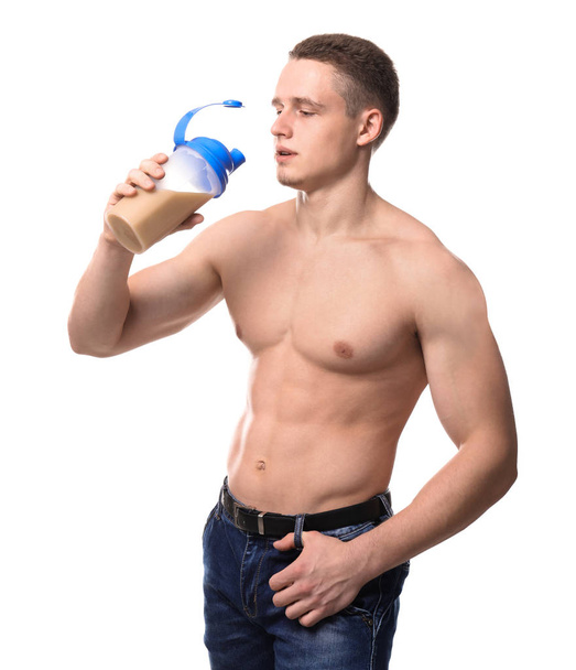 Muscular young bodybuilder with bottle of protein cocktail on white background - Фото, зображення
