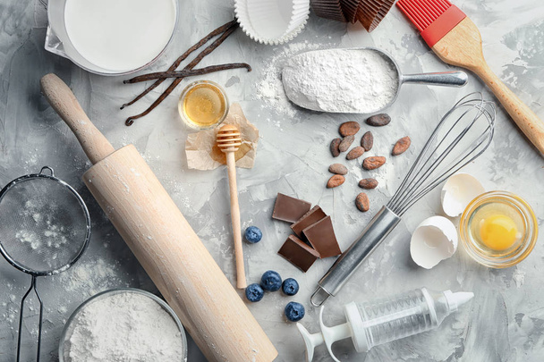 Ingredients and utensils for cooking pastries on grey background - Foto, Imagen