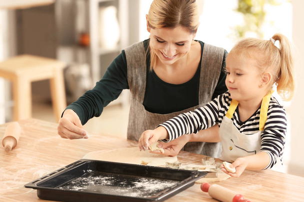 Mãe e filha com massa de farinha à mesa em casa
 - Foto, Imagem