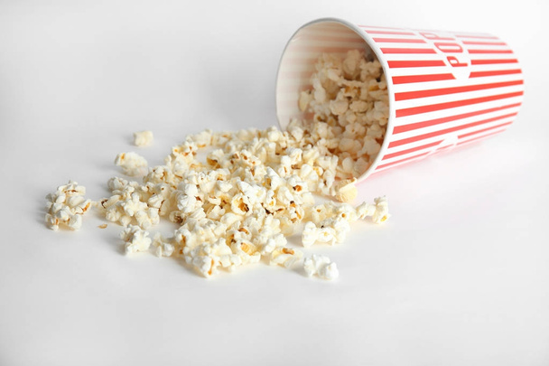 Paper cup with tasty popcorn on white background - Foto, afbeelding