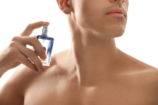 Handsome man with bottle of perfume on white background, closeup - Foto, Bild