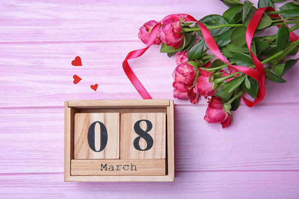 Roses and block calendar on wooden background, top view. Composition for International Women's Day - Fotoğraf, Görsel