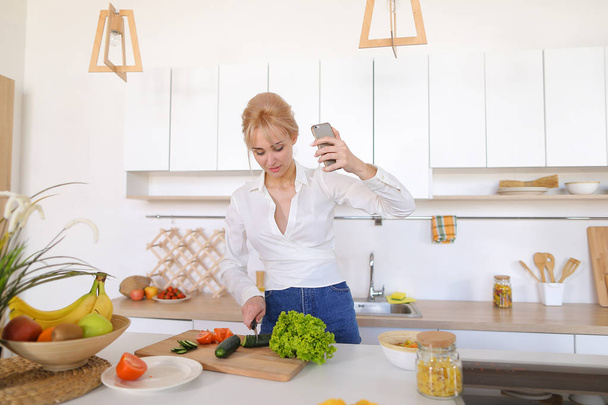 Заманчивая женщина держит мобильный телефон и звонки видеосвязи, стоя
 - Фото, изображение