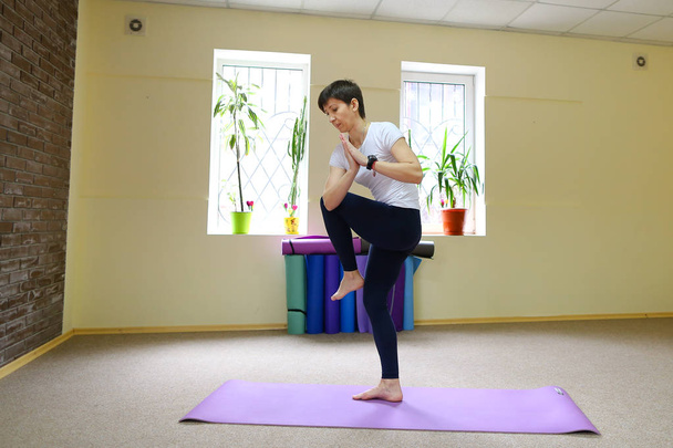 Joven mujer de aspecto americano realiza asanas de yoga
. - Foto, imagen