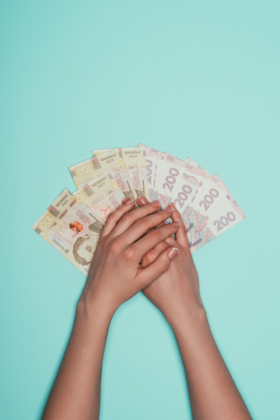 cropped shot of woman with bunch of cash isolated on turquoise - Photo, Image