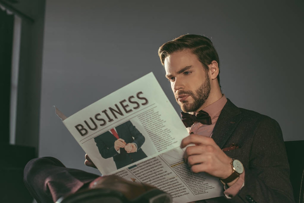 schöner stylischer junger Mann liest Wirtschaftszeitung - Foto, Bild