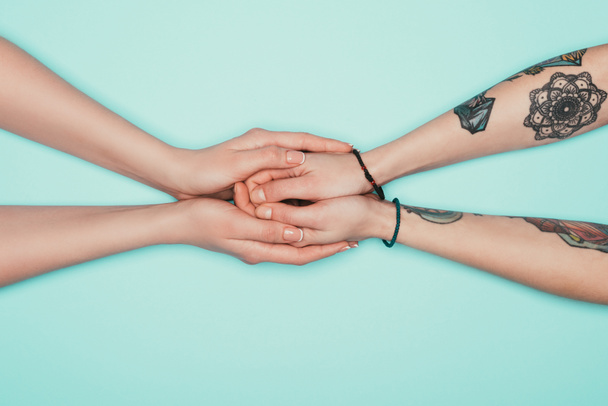 oříznuté záběr smyslné ženy držící rukou navzájem izolovaných na tyrkysové - Fotografie, Obrázek