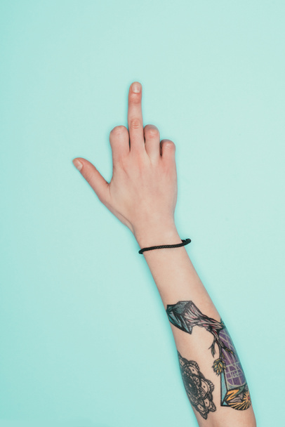 recortado tiro de mujer mostrando el dedo medio aislado en turquesa
 - Foto, imagen