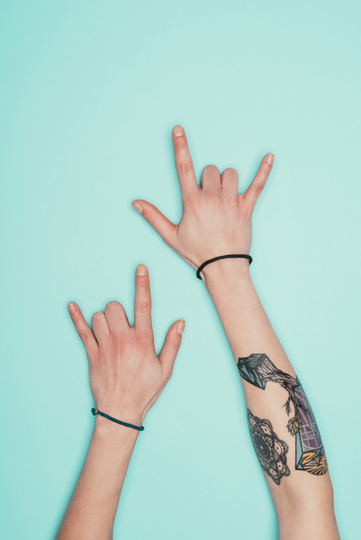 cropped shot of woman showing horns signs isolated on turquoise - Foto, imagen