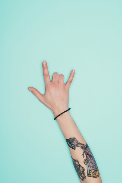 cropped shot of woman showing horns sign isolated on turquoise - Fotografie, Obrázek