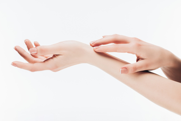 colpo ritagliato di donna che applica crema per la cura della pelle su mani isolate su bianco
 - Foto, immagini