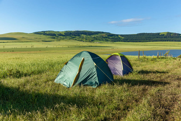 Two tents in a meadow near the water, landscape. Two tents, a landscape.journey to Georgia - 写真・画像