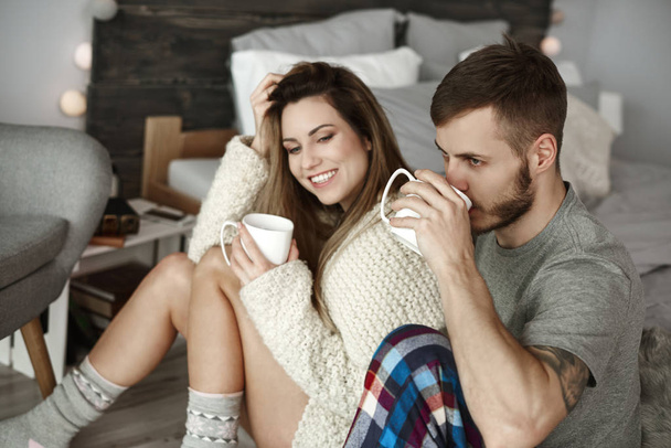 Affectionate couple drinking morning coffee at bedroom  - Photo, Image