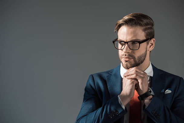 retrato de hombre de negocios elegante guapo en gafas mirando hacia otro lado aislado en gris
 - Foto, Imagen
