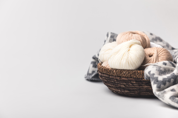 colored yarn balls in wicker basket with blanket isolated on white  - Photo, Image