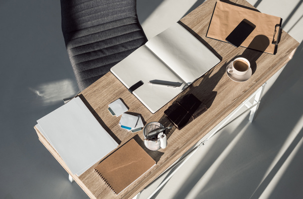 top view of blank notebooks, cup of coffee and smartphone on table in office - Zdjęcie, obraz