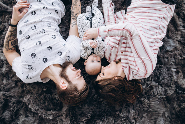 Vanhemmat ja tytär makaavat matolla. Yläkuva
 - Valokuva, kuva
