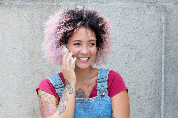 Beautiful punk girl with pink hair talking at phone - 写真・画像
